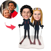 בובה זוגית בעיצוב אישי - חופשת סקי מושלמת: דמויות של זוג עם ציוד סקי, לבוש חורפי ועיצוב בהתאמה אישית מתמונות הלקוחות, מושלמות לחובבי חופשות חורפיות.